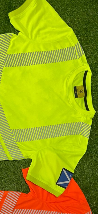 High-visibility safety shirt with reflective stripes on a grassy background